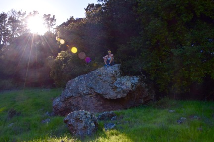Guy sitting atop a rock outcropping