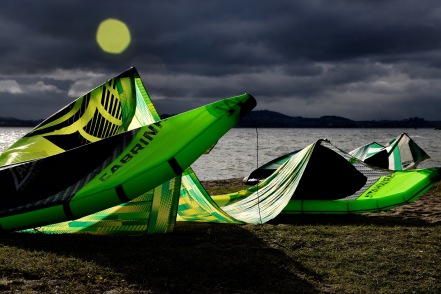 Green kite surfing kite resting on the sand