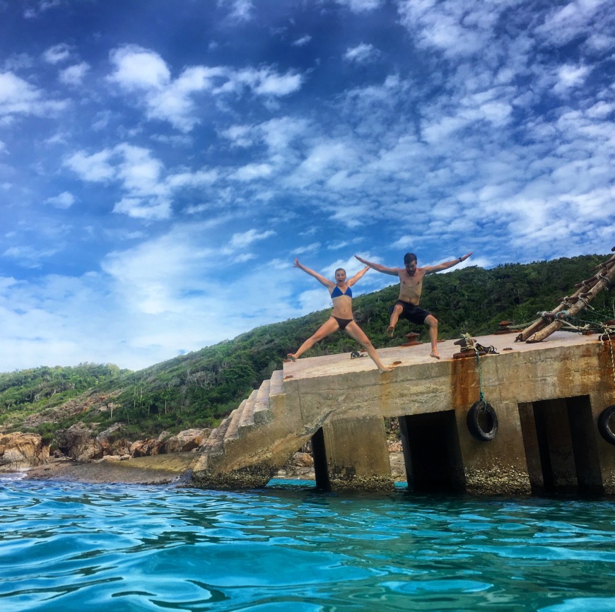 Alli and TJ jumping off the broken dock at the bottom of the windmill staircase and enjoying the blue lagoon